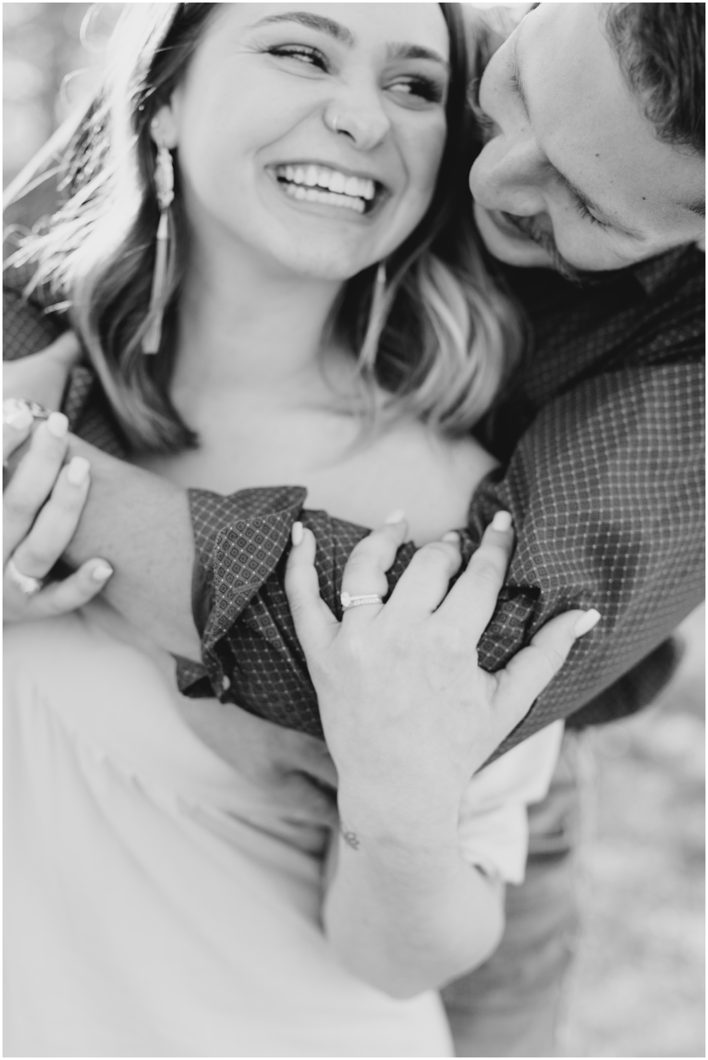 a couple is hugging and laughing together during their college station engagement session