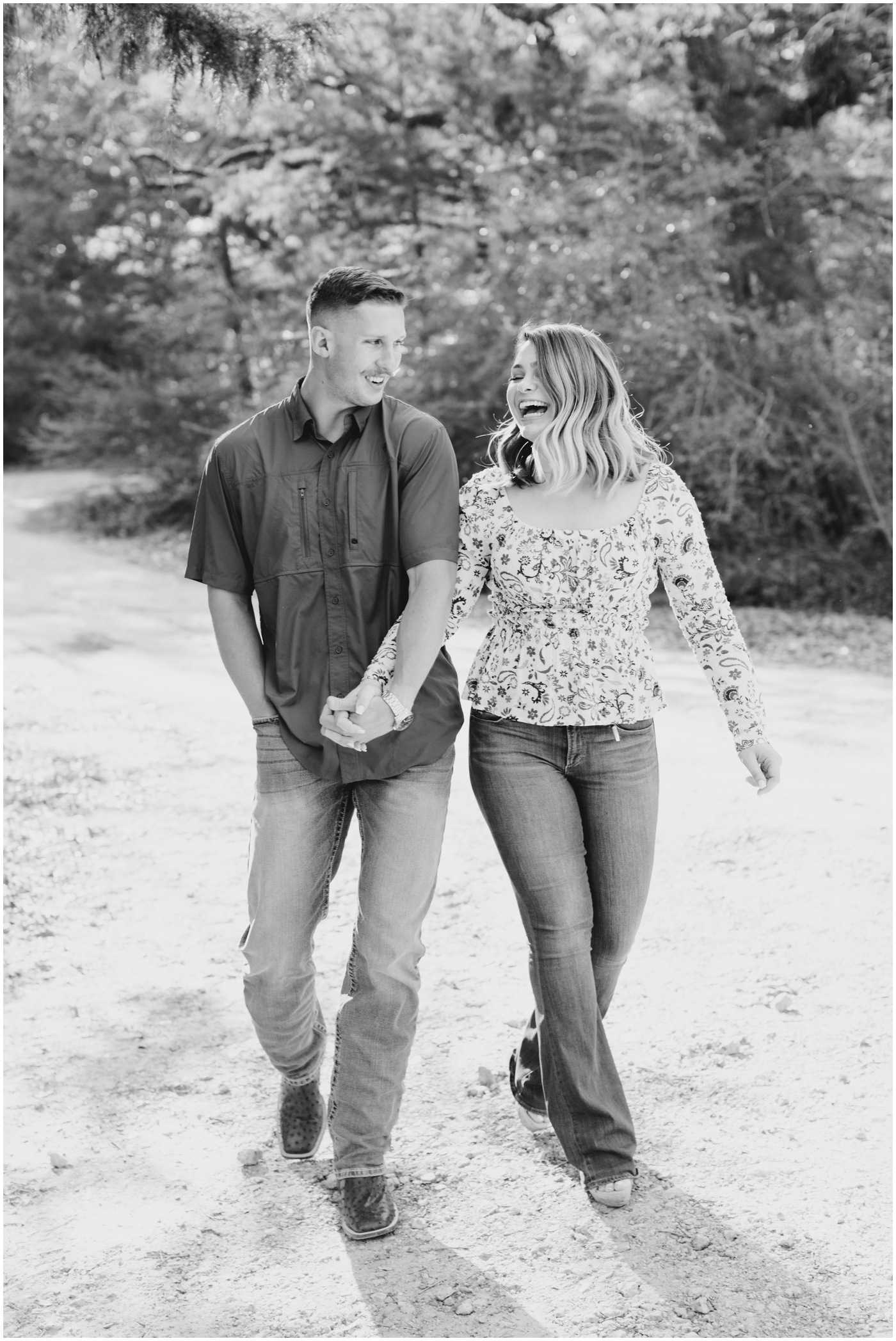 a couple walks and laughs together during their college station engagement session