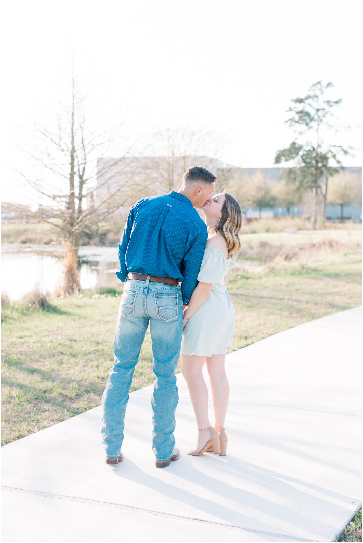 a couple kisses at sunset during their college station engagement session