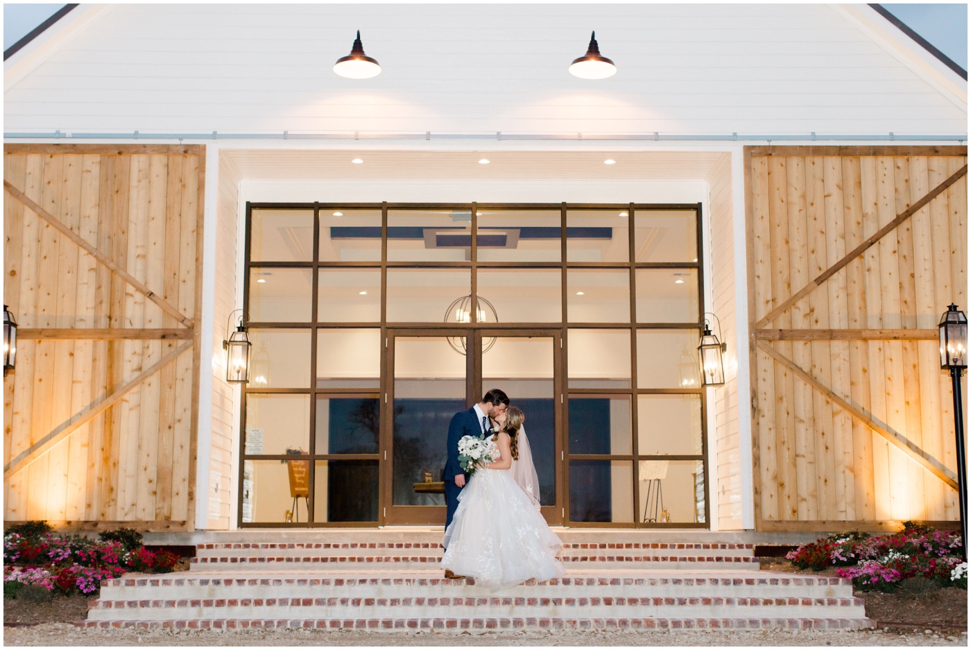 a bride and groom kiss in front of their texas wedding venue