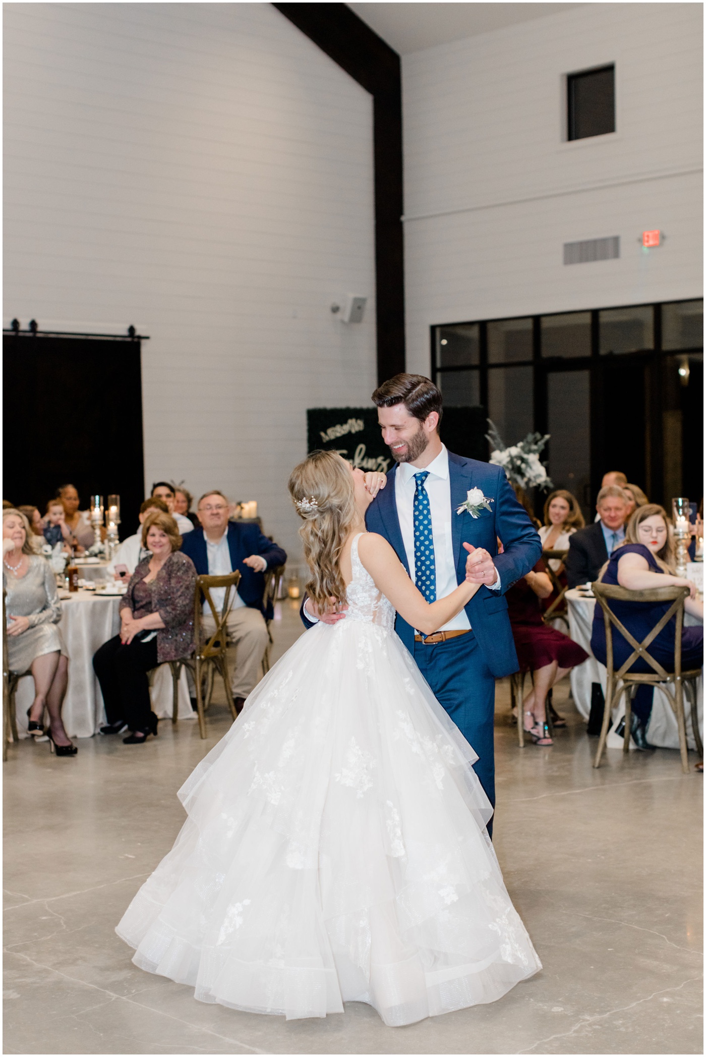 bride and groom are smiling during their first dance 