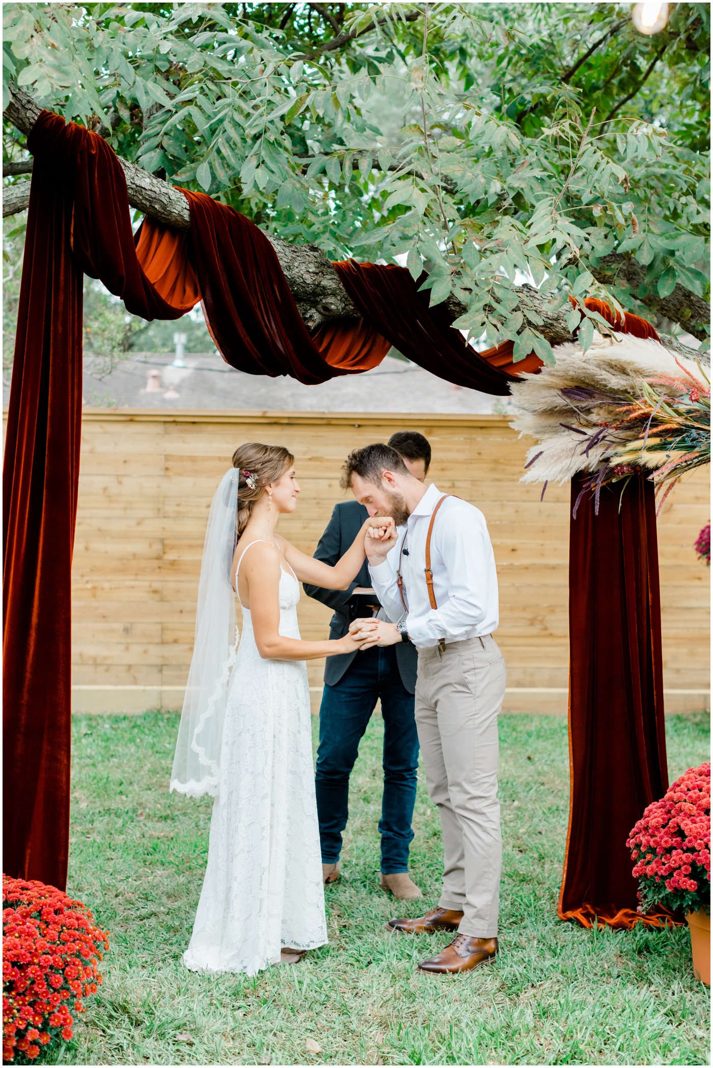 groom kisses brides hand during houston micro wedding ceremony