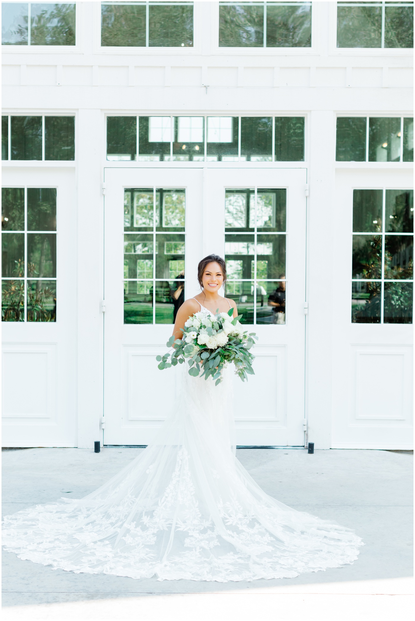 a bride is smiling with her bouquet 