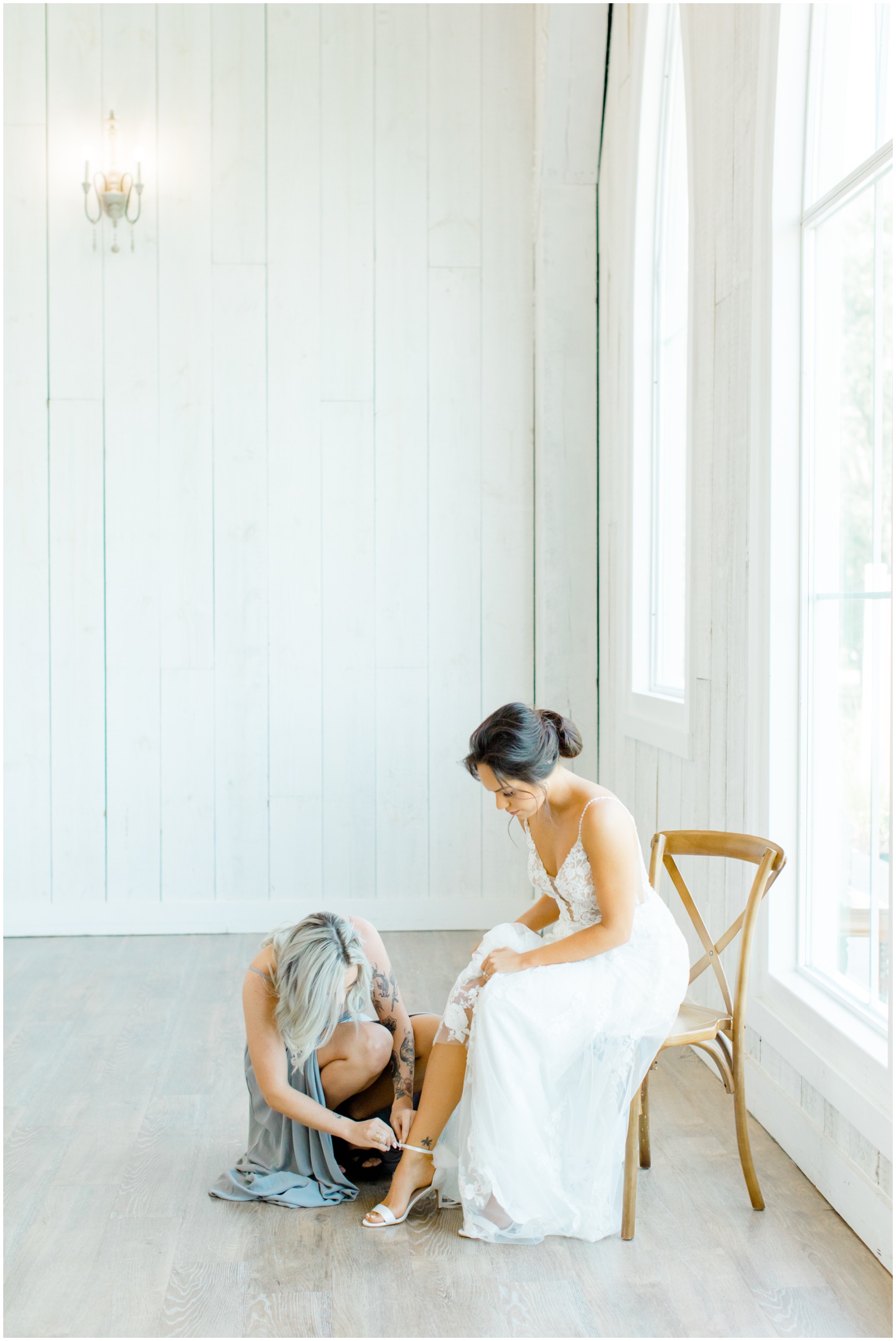 wedding photographer in Houston captures maid of honor putting on brides shoes 