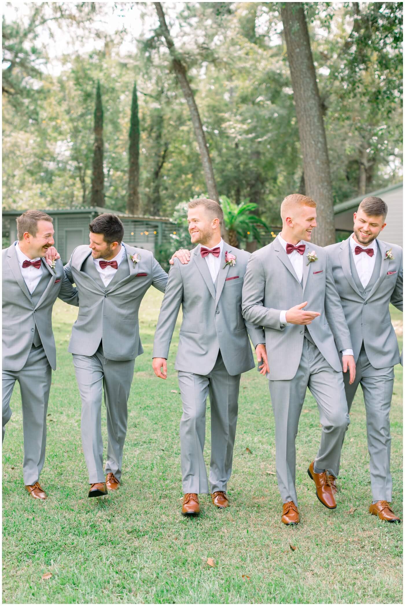 a groom laughs as he walks with his groomsmen
