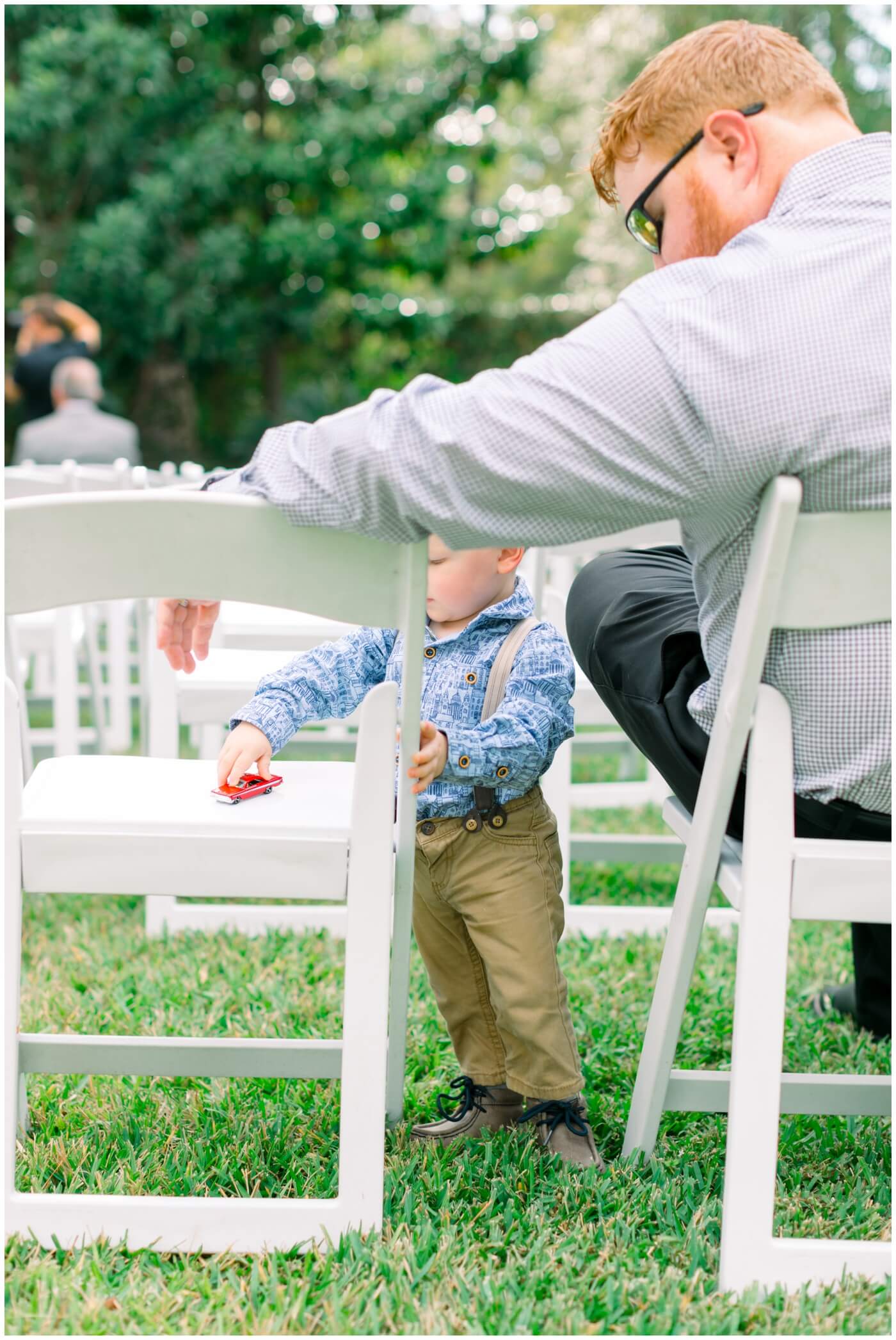 a little boy plays with a toy during the wedding ceremony