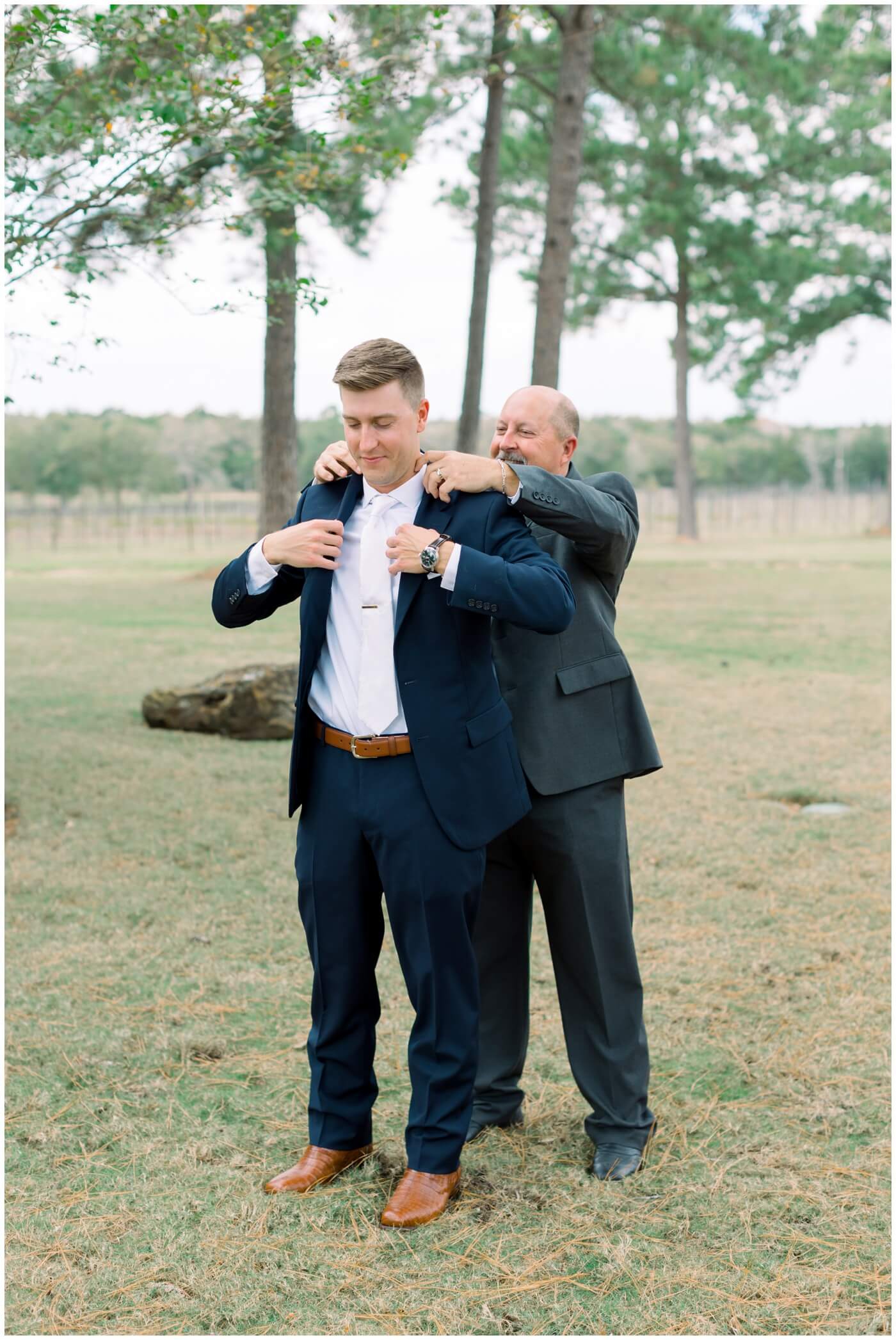 Houston Wedding at The Vine | the groom's father helps the groom put on his jacket