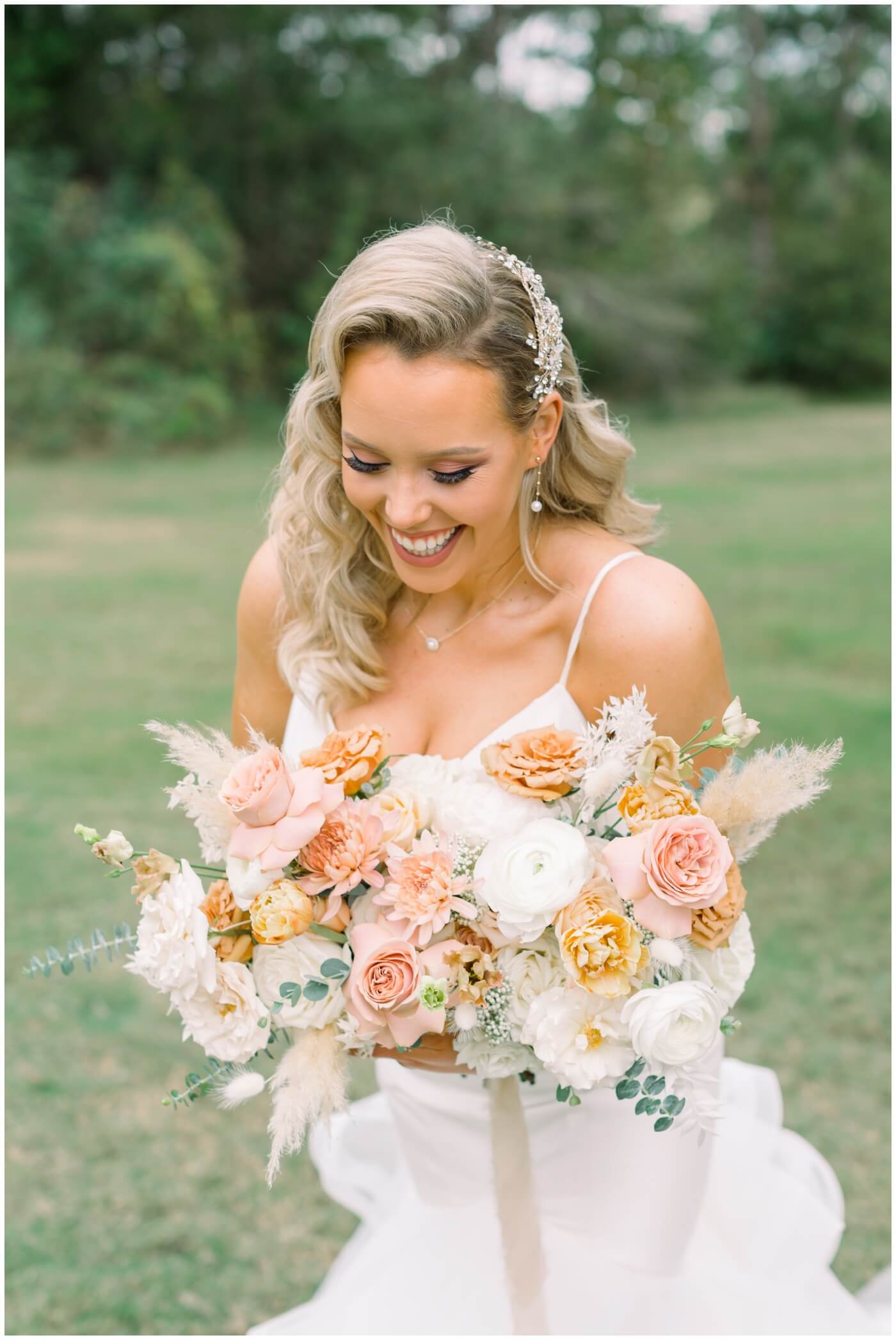 Houston Wedding at The Vine | the bride laughing with her bouquet 