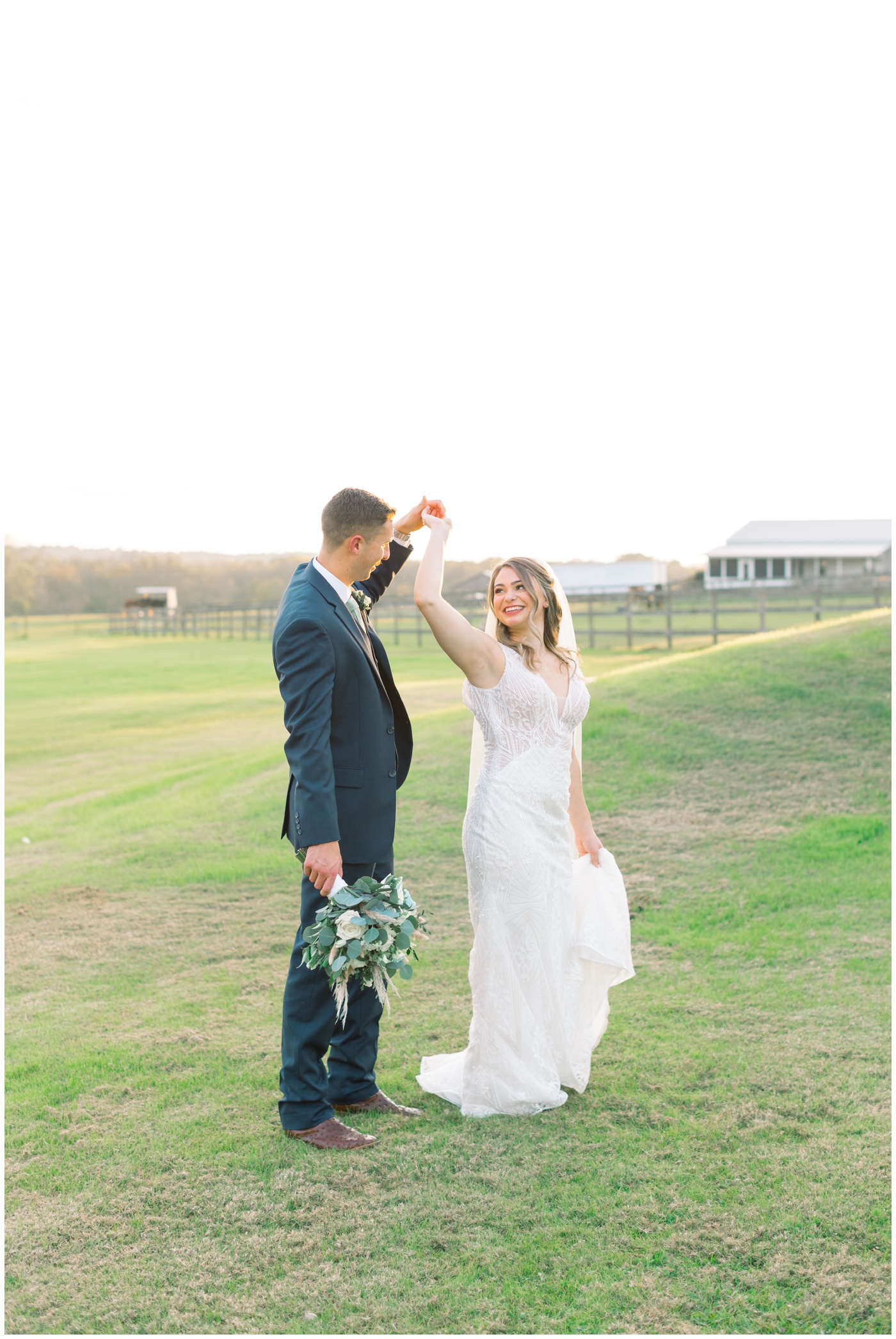 Texas farmhouse wedding | the groom twirls his bride and admires her 