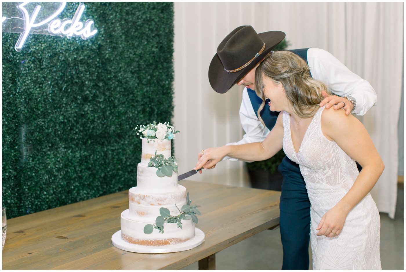 Texas farmhouse wedding | the bride and groom laugh as they cut their wedding cake 