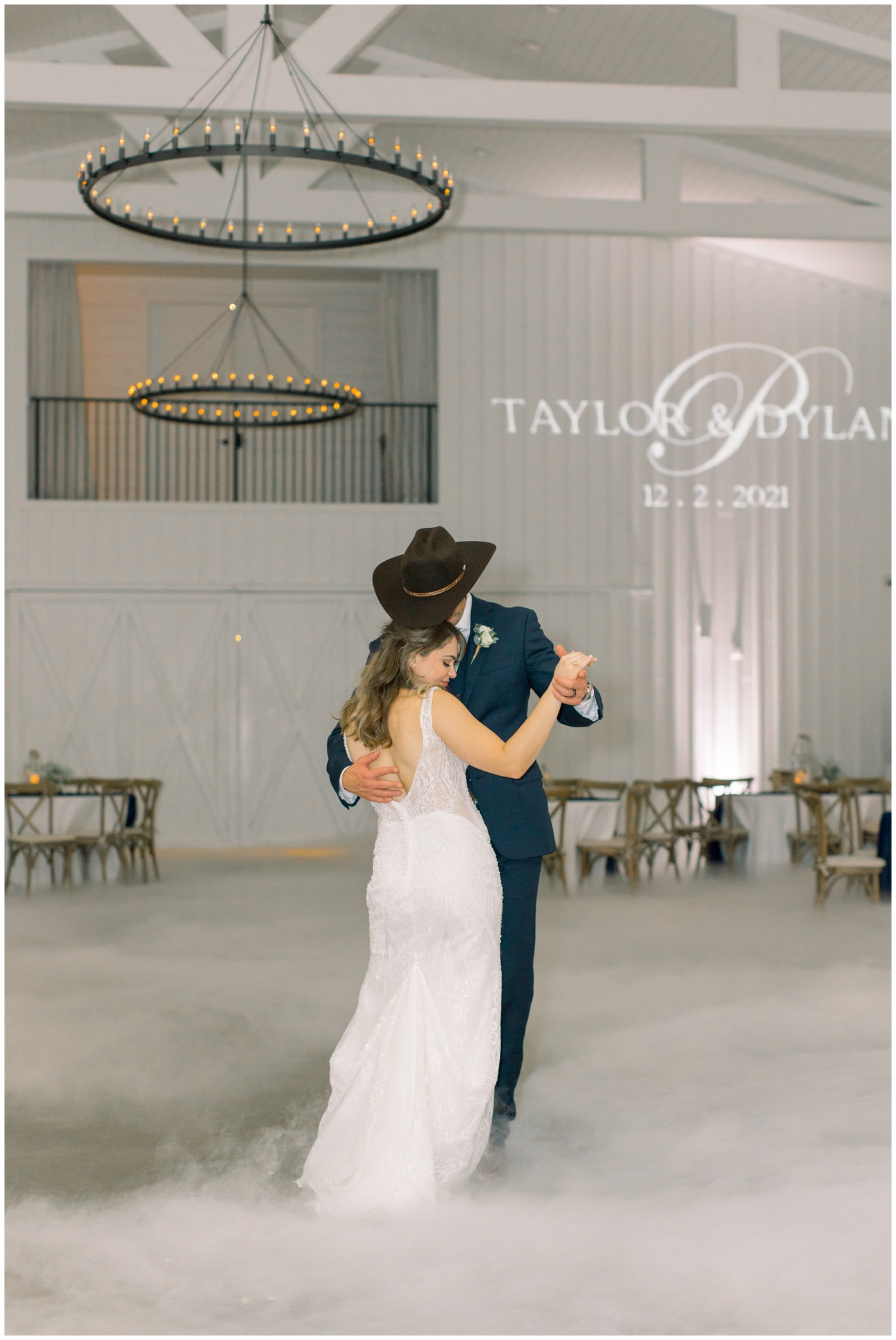 the bride and groom smile sweetly as they share a private dance together at their Texas farmhouse wedding.