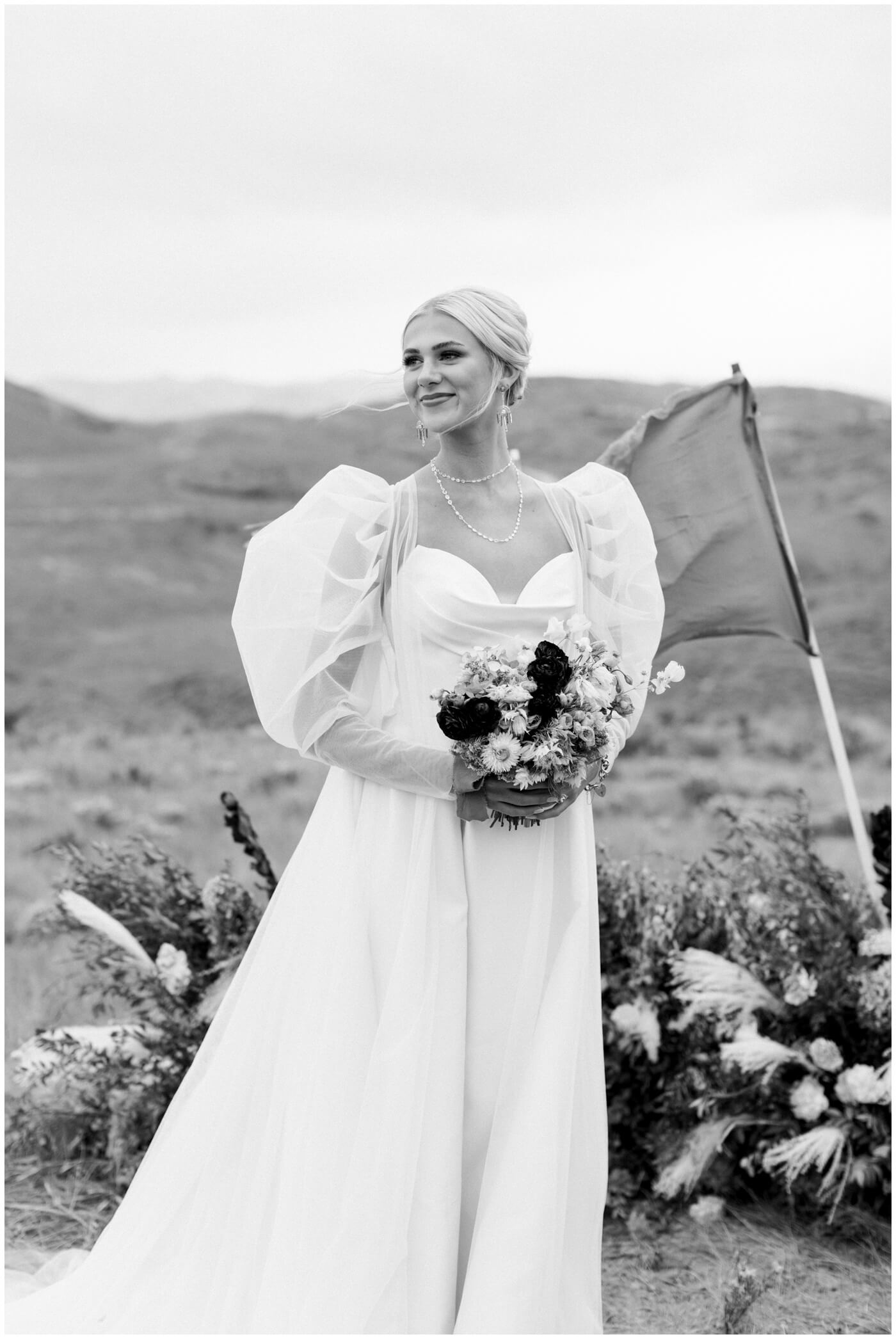 Wedding in the mountains | A bride smiles holding flowers on her wedding day 