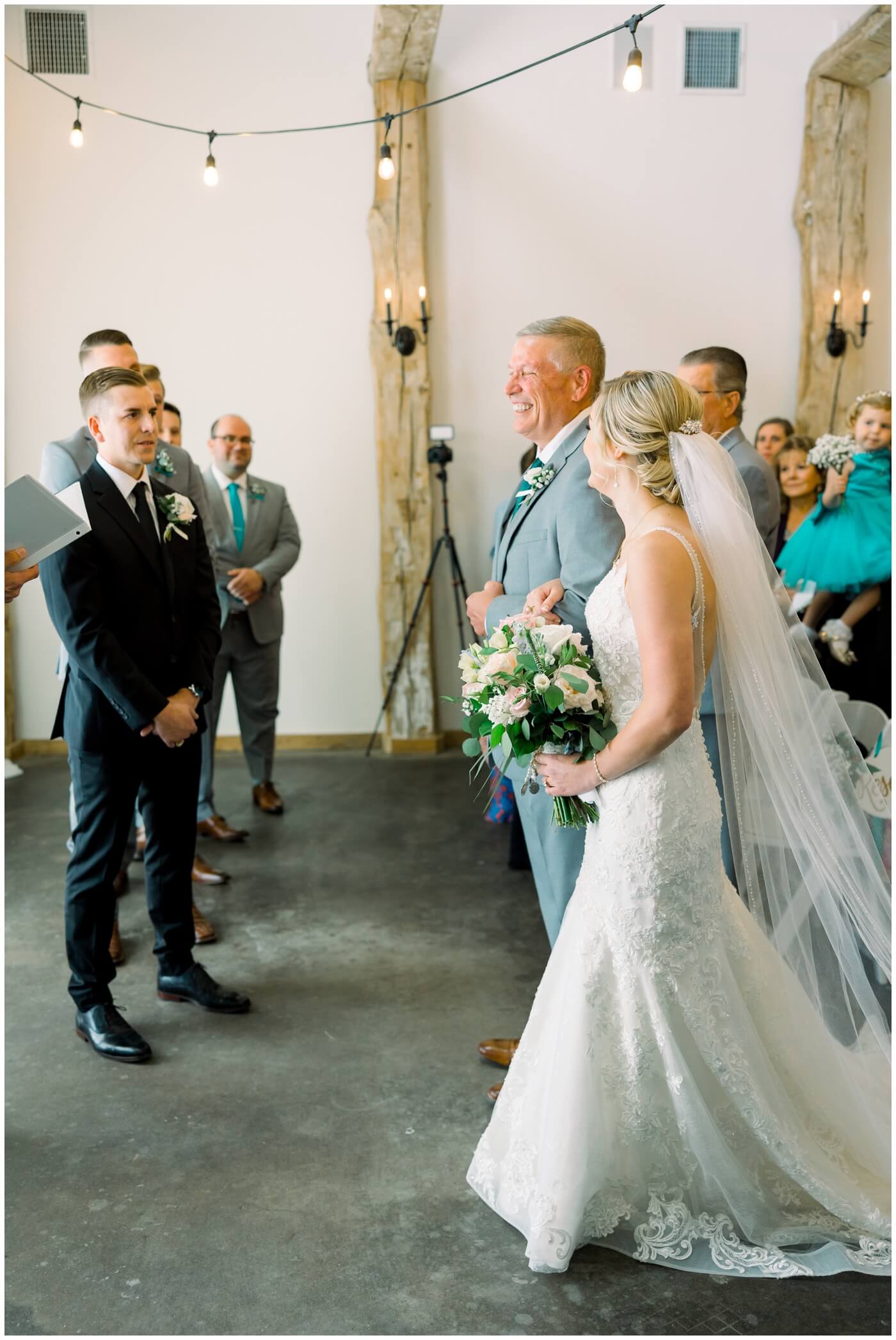 The father of the bride smiles as he walks his daughter down the aisle