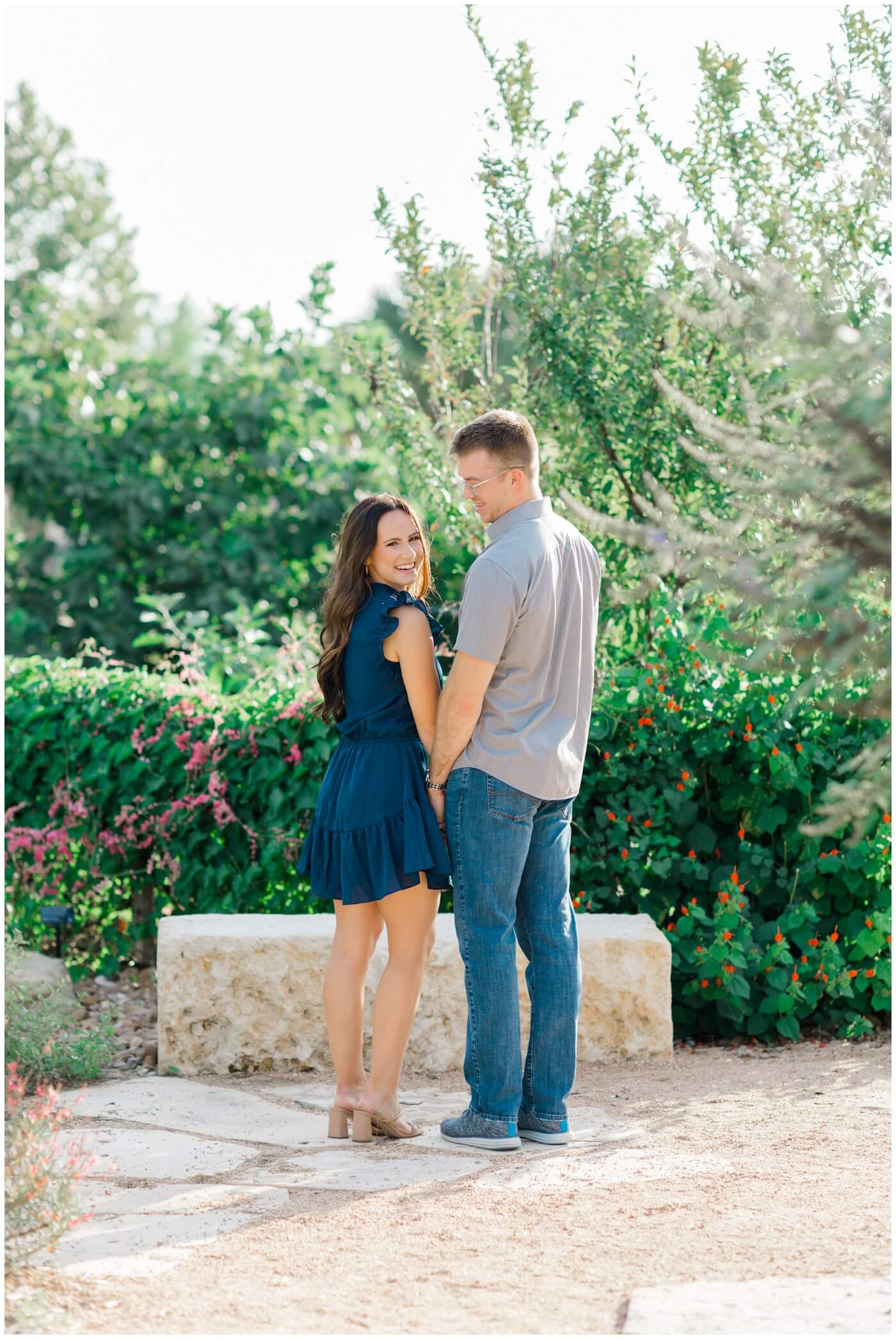 A couple smiles during their engagement session at the TAMU Gardens.