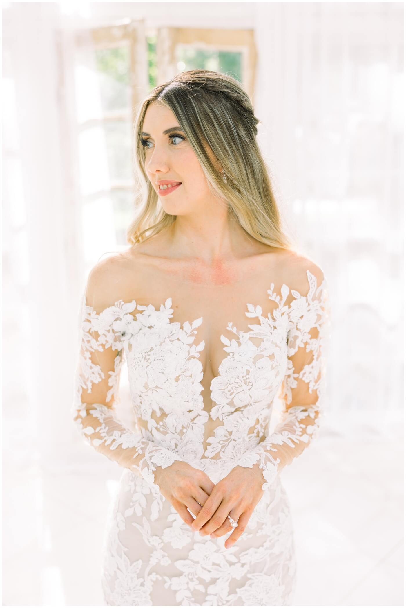 Wedding photographer in Houston | A bride shows the beautiful lace design on her wedding dress