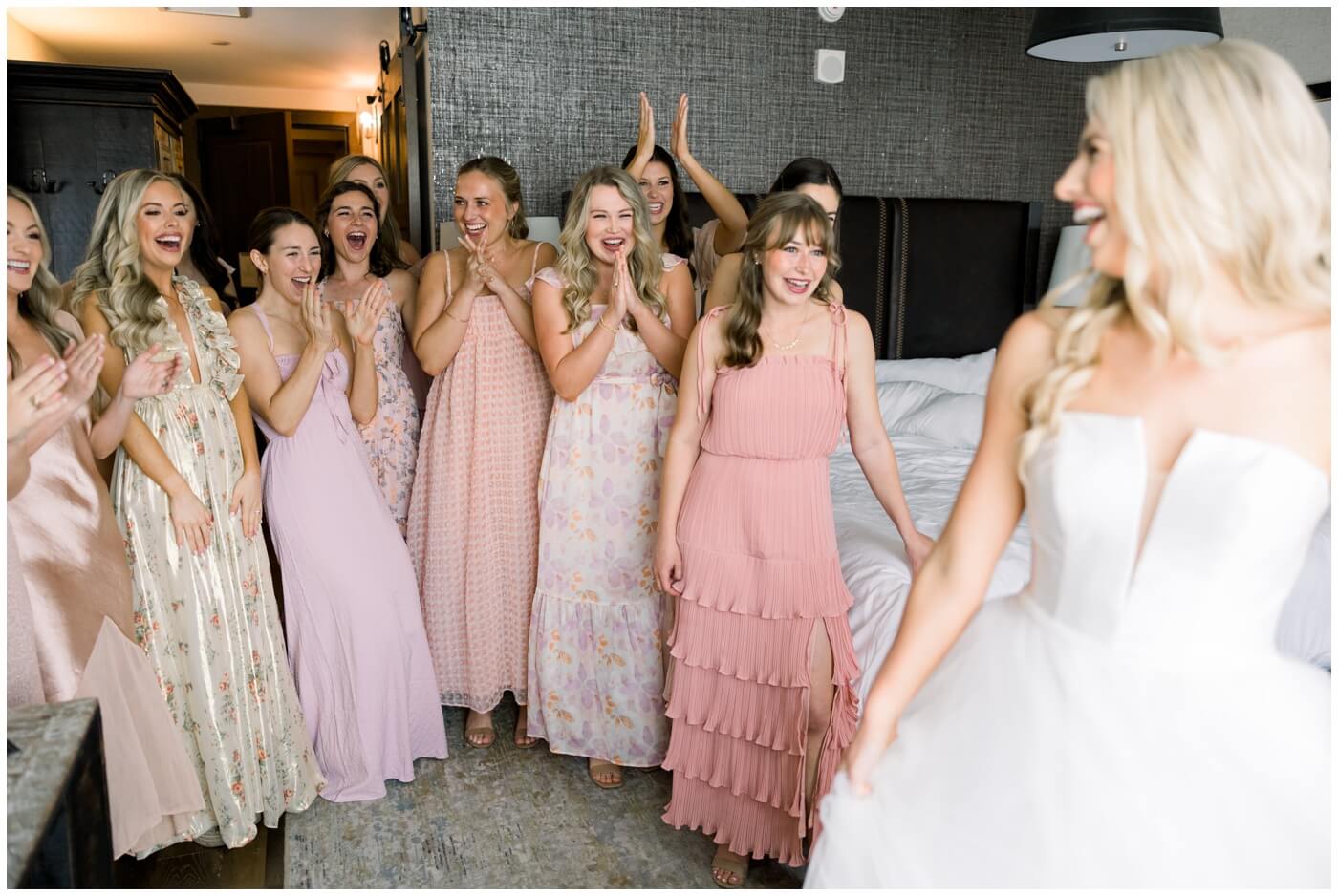 Bridesmaids smile and cheer as they see the bride on her wedding day at Hotel Drover