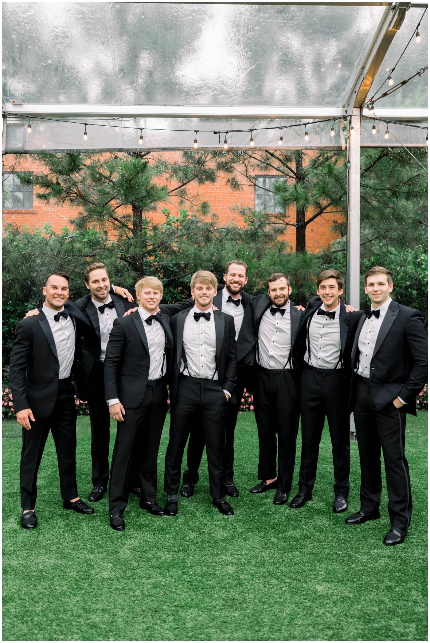 The Groom smiles with his groomsmen on his wedding day