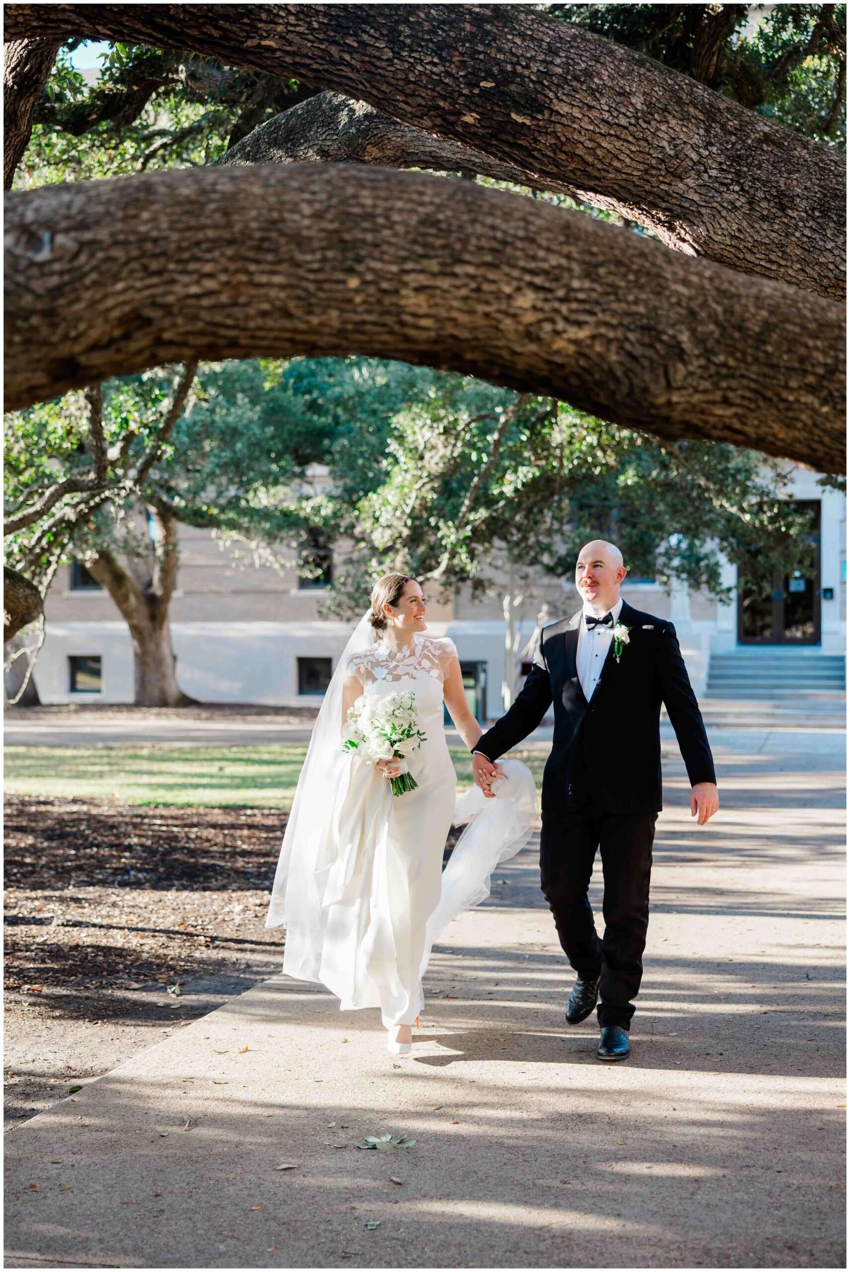 the newlyweds walk under the century tree at Texas A&M University