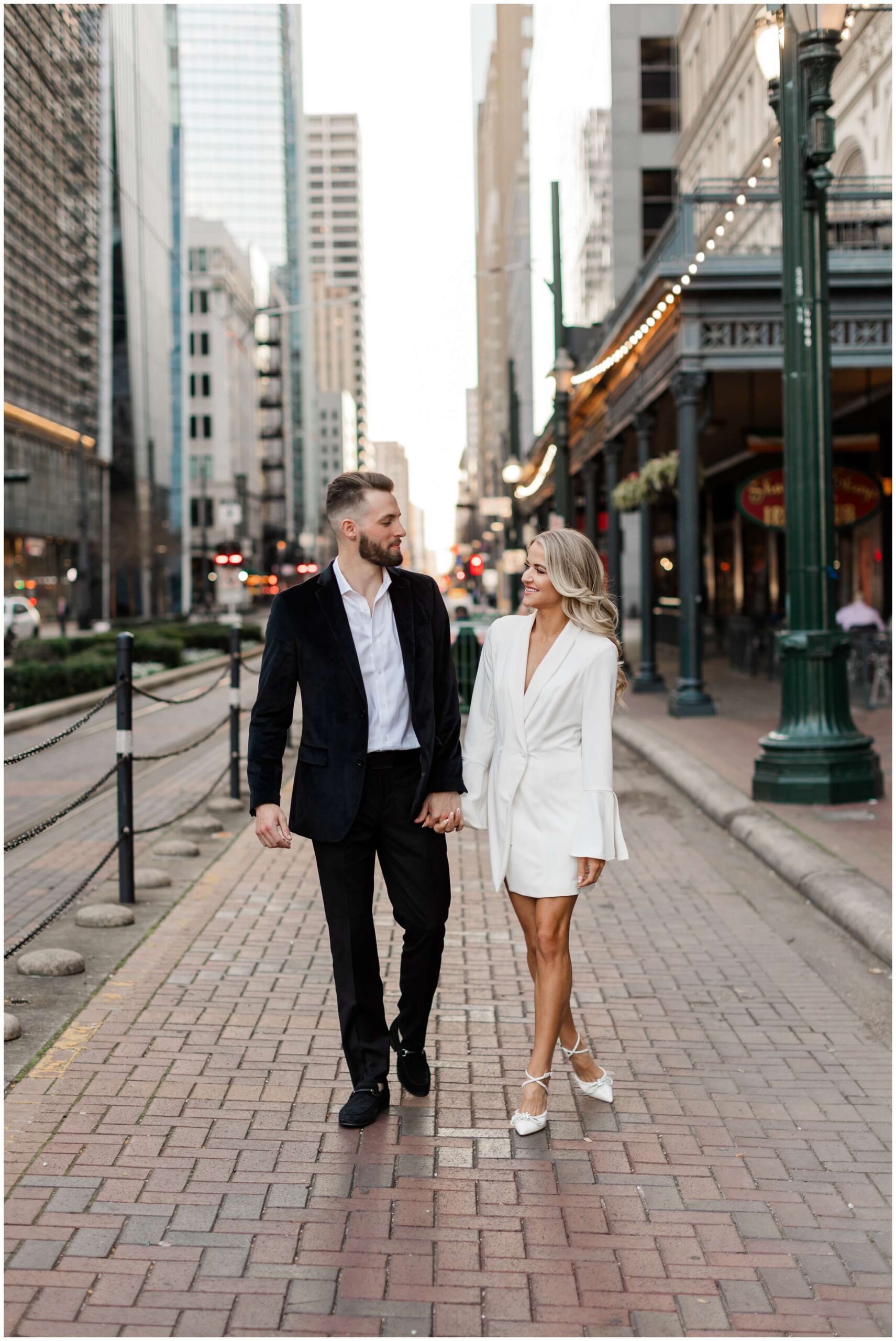a couple stroll through the city streets for their Houston engagement photos