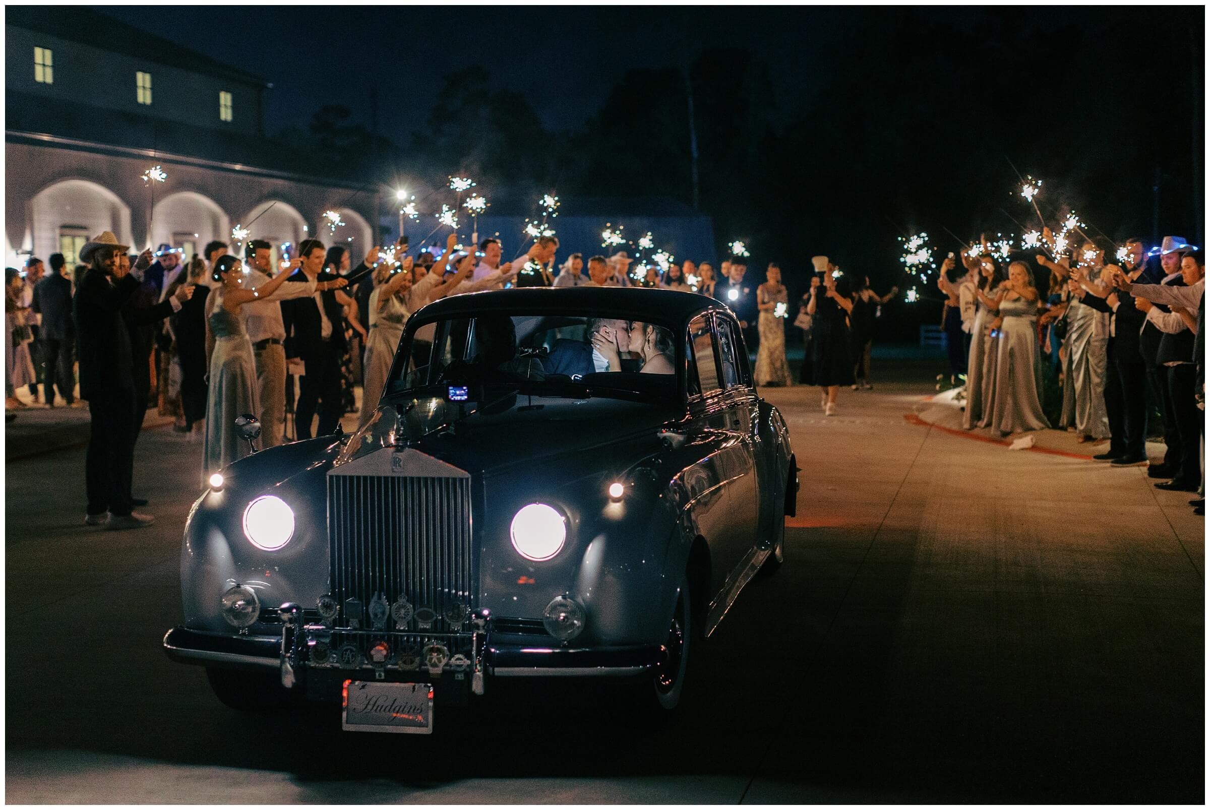 Vintage getaway car from Royal Coach Classic parked outside The Blue Magnolia wedding venue.